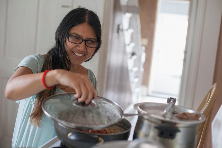 Woman with visual impairment cooking food in the kitchen